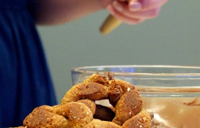 Rosquinhas fit de banana e aveia, assadas e empilhadas com cobertura de Nutren chocolate ao fundo