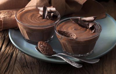 Foto de duas pequenas tigelas com mousse de chocolate dentro em cima de um prato azul Foto de duas pequenas tigelas com mousse de chocolate dentro em cima de um prato azul