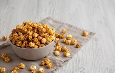 Fotografia em tons claros de um recipiente fundo médio em tom cinza sobre um paninho dobrado da mesma cor, apoiados em uma mesa de madeira clara.