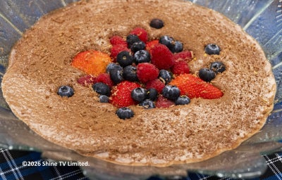 Foto da Receita de Mousse de Chocolate com Café e Licor servida em travessa de vidro com frutas vermelhas na decoração
