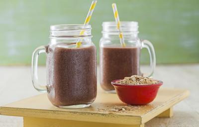 foto tirada de dois copos transparentes e ambos contém a vitamina de Açaí, à frente contém um potinho redondo vermelho com Neston