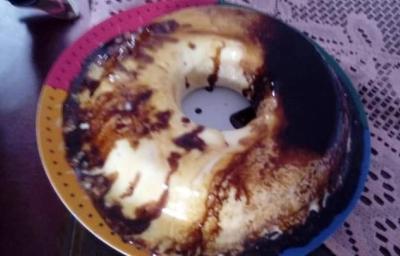 Fotografia de um bolo de sorvete com calda de açúcar e chocolate sobre um apoio colorido e uma mesa escura. Fotografia de um bolo de sorvete com calda de açúcar e chocolate sobre um apoio colorido e uma mesa escura.