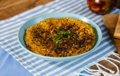 Fotografia em tons de azul com um prato azul ao centro. Em cima do prato existe uma receita de batata-doce rosti recheada com carne desfiada Fotografia em tons de azul com um prato azul ao centro. Em cima do prato existe uma receita de batata-doce rosti recheada com carne desfiada