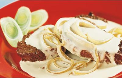 foto tirada de uma prato redondo e vermelho com dois bifes, creme por cima e cebolas foto tirada de uma prato redondo e vermelho com dois bifes, creme por cima e cebolas