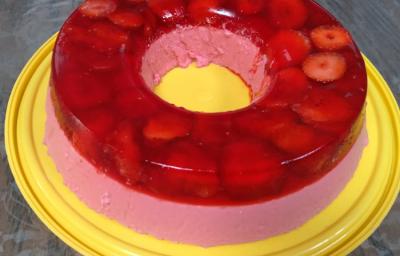 Foto em tons de vermelho da receita de super gelatina de morango servida sobre uma base circular amarela Foto em tons de vermelho da receita de super gelatina de morango servida sobre uma base circular amarela