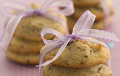 Foto com 3 cookies um em cima do outro amarrados com um cetim rosa, no fundo da foto há outros 2 cookies da mesma maneira Foto com 3 cookies um em cima do outro amarrados com um cetim rosa, no fundo da foto há outros 2 cookies da mesma maneira