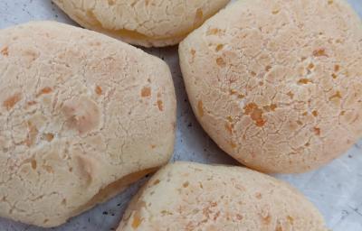 Fotografia de quatro pães de queijo sobre uma forma de alumínio. Fotografia de quatro pães de queijo sobre uma forma de alumínio.