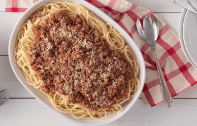 em uma mesa contém um recipiente que comporta o macarrão, ao lado um prato com uma quantidade de macarrão. Ao lado do recipiente contém um pano nas cores vermelho e rosa, e ao lado desse pano dois pratos com dois garfos por cima. em uma mesa contém um recipiente que comporta o macarrão, ao lado um prato com uma quantidade de macarrão. Ao lado do recipiente contém um pano nas cores vermelho e rosa, e ao lado desse pano dois pratos com dois garfos por cima.