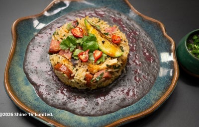 PF Mexidão com arroz, frango e linguiça dourados, servido com creme aveludado de feijão-preto, coentro fresco e toque cítrico de limão.
