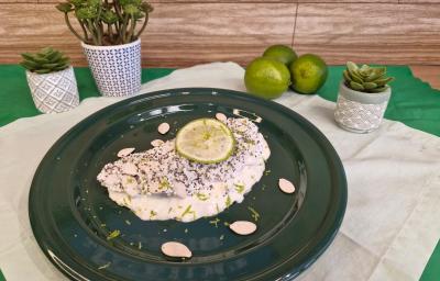 Foto em tons de branco da receita de tapioca servida com uma rodela de limão por cima, sobre um prato preto em cima de uma toalha de linho com limões e vasinhos de planta ao lado Foto em tons de branco da receita de tapioca servida com uma rodela de limão por cima, sobre um prato preto em cima de uma toalha de linho com limões e vasinhos de planta ao lado
