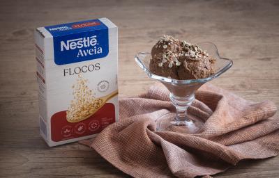 Foto da receita de sorvete de banana, cacau e aveia servida em uma taça de vidro sobre um pano marrom claro em cima de uma mesa de madeira Foto da receita de sorvete de banana, cacau e aveia servida em uma taça de vidro sobre um pano marrom claro em cima de uma mesa de madeira