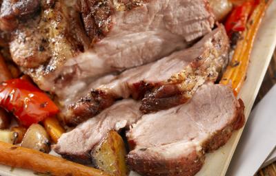 Fotografia em tons de marrom tirada de um pernil com diversas fatias à frente. Fotografia em tons de marrom tirada de um pernil com diversas fatias à frente.