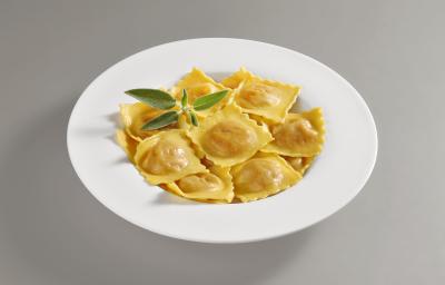 Foto da receita de Tortelli. Observa-se um prato repleto de tortellis com sálvia em um prato branco redondo. Foto da receita de Tortelli. Observa-se um prato repleto de tortellis com sálvia em um prato branco redondo.
