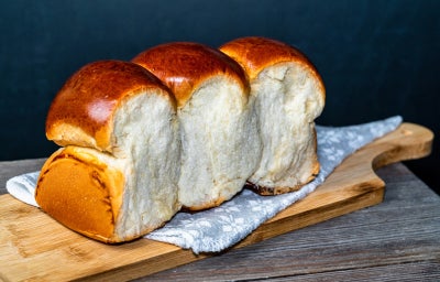 imagem mostra um pão shokupan dourado, com miolo branco, macio e fofinho, cortado em fatias.