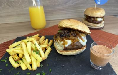 Fotografia de dois hambúrgueres acompanhados de uma porção de batatas fritas e um molho avermelhado. Fotografia de dois hambúrgueres acompanhados de uma porção de batatas fritas e um molho avermelhado.