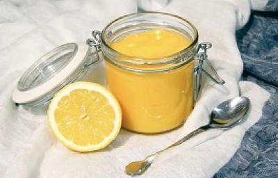 Foto da receita de Lemon Curd. Observa-se um potinho de vidro hermético com o creme de limão dentro e, ao lado esquerdo, um limão pela metade decora a foto. Foto da receita de Lemon Curd. Observa-se um potinho de vidro hermético com o creme de limão dentro e, ao lado esquerdo, um limão pela metade decora a foto.
