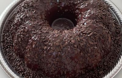 Foto em tons de marrom da receita de bolo cenourolate servida em uma porção grande sobre uma forma descartável branca Foto em tons de marrom da receita de bolo cenourolate servida em uma porção grande sobre uma forma descartável branca