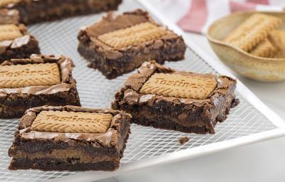Foto da receita de Brownie de Tostines. Observa-se 5 fatias de brownie com o Biscoito TOSTINES Especiarias em cima e recheado de creme. Foto da receita de Brownie de Tostines. Observa-se 5 fatias de brownie com o Biscoito TOSTINES Especiarias em cima e recheado de creme.