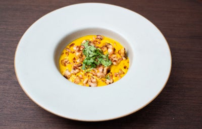 Creme de abóbora moranga com bacon crocante, carne suína e ervas, servido em cumbuca