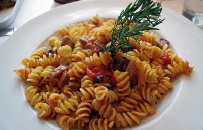 fotografia em tons de branco e bege tirada de uma prato redondo branco, dentro contém macarrão parafuso com pedaços de bacon. fotografia em tons de branco e bege tirada de uma prato redondo branco, dentro contém macarrão parafuso com pedaços de bacon.