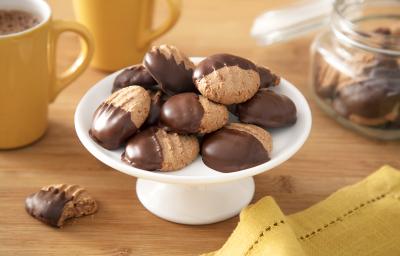 Foto da receita de Biscoitinho de Cappuccino. Observa-se uma boleira branca com 8 biscoitinhos em cima, banhados pela metade com chocolate. Foto da receita de Biscoitinho de Cappuccino. Observa-se uma boleira branca com 8 biscoitinhos em cima, banhados pela metade com chocolate.