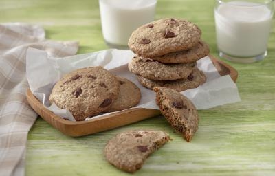 Foto da receita de Cookie Vegano. Observa-se 7 cookies dispostos em uma tábua de madeira, sendo que um está cortado ao meio. Foto da receita de Cookie Vegano. Observa-se 7 cookies dispostos em uma tábua de madeira, sendo que um está cortado ao meio.