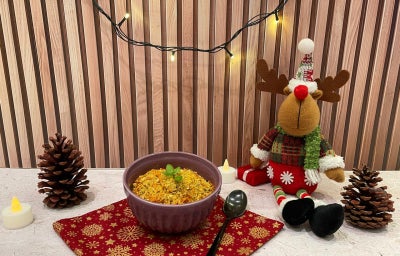 Fotografia em tons de vermelho com um pote roxo ao meio e a farofa de cenoura dentro.