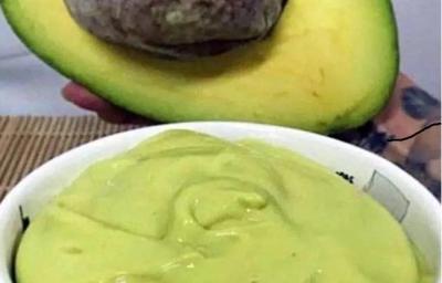 Foto da receita de Mousse de Abacate. Observa-se um potinho branco com a mousse cremosa dentro e um abacate pela metade atrás ilustrando. Foto da receita de Mousse de Abacate. Observa-se um potinho branco com a mousse cremosa dentro e um abacate pela metade atrás ilustrando.