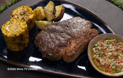 Bife de chorizo grelhado com milho e batatas, servido com chimichurri caseiro em cumbuca