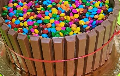 Foto em tons de marrom da receita de bolo de cerquinha decorado com confetes coloridos servida sobre uma base prateada Foto em tons de marrom da receita de bolo de cerquinha decorado com confetes coloridos servida sobre uma base prateada