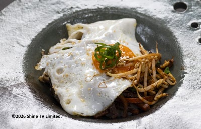 Bibimbap coreano com arroz, legumes salteados, brotos, cebolinha e ovo com gema mole