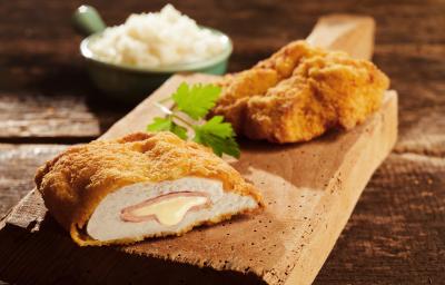 Foto da receita de Filé de Frango à Cordon Bleu. Observa-se um filé de frango cortado ao meio, expondo o recheio de presunto e queijo derretido. Foto da receita de Filé de Frango à Cordon Bleu. Observa-se um filé de frango cortado ao meio, expondo o recheio de presunto e queijo derretido.