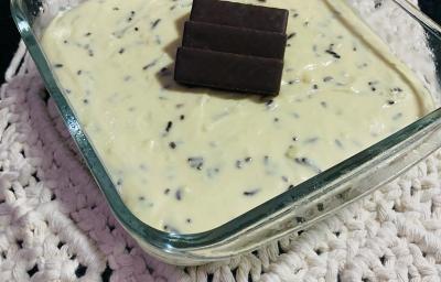 Foto em tons de branco da receita de moça gelada servida em uma travessa de vidro retangular sobre um paninho bordado Foto em tons de branco da receita de moça gelada servida em uma travessa de vidro retangular sobre um paninho bordado