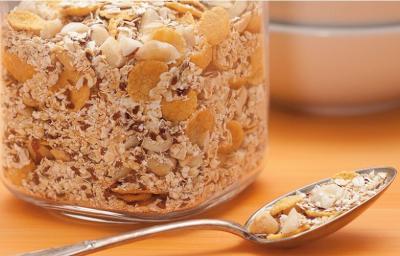 fotografia em tons de marrom tirada de uma bancada marrom vista de frente, contém um pote transparente com granola. fotografia em tons de marrom tirada de uma bancada marrom vista de frente, contém um pote transparente com granola.