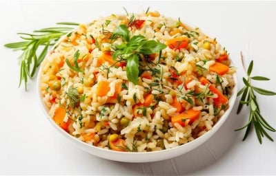 Visto de cima, prato branco redondo com arroz soltinho, cenouras cortadas em cubos, ervilhas e pedaços de cheiro-verde picados. Visto de cima, prato branco redondo com arroz soltinho, cenouras cortadas em cubos, ervilhas e pedaços de cheiro-verde picados.