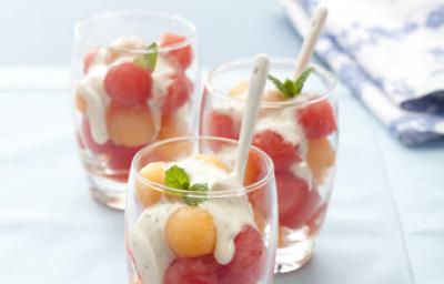 3 copos transparentes com bolinhas de melão e melancia com creme por cima 3 copos transparentes com bolinhas de melão e melancia com creme por cima