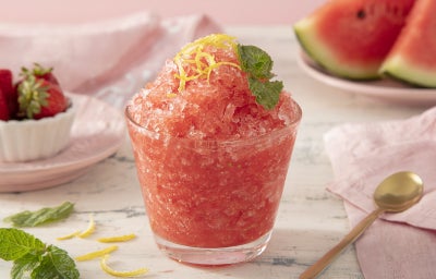Imagem mostra uma taça com um creme congelado em tons vermelho e cor de rosa com folhas de hortelã por cima