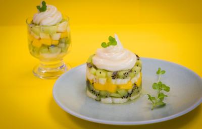 fotografia em tons de amarelo e branco, contém um prato redondo e branco com Tartar com pedaços de frutas e creme por cima e ao fundo uma taça transparente com pedaços de frutas e creme por cima. fotografia em tons de amarelo e branco, contém um prato redondo e branco com Tartar com pedaços de frutas e creme por cima e ao fundo uma taça transparente com pedaços de frutas e creme por cima.
