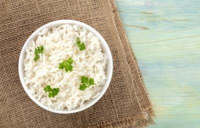 fotografia em tons de azul, marrom e branco de uma bancada azul vista de cima. Contém um pano marrom ao lado esquerdo, por cima um recipiente redondo branco com arroz e salsa. fotografia em tons de azul, marrom e branco de uma bancada azul vista de cima. Contém um pano marrom ao lado esquerdo, por cima um recipiente redondo branco com arroz e salsa.