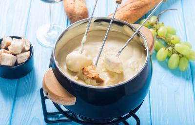 Foto da Receita de Fondue de Queijo Sem Lactose. Observa-se uma panelinha de fondue azul com três espátulas de pão dentro. Foto da Receita de Fondue de Queijo Sem Lactose. Observa-se uma panelinha de fondue azul com três espátulas de pão dentro.