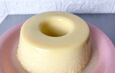 Fotografia em tons claros com um pudim de cor neve ao centro. O pudim é feito com pasta GALAK NESTLÉ professional com textura lisinha e sem calda