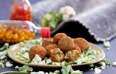 Foto da receita de bolinho de talos, servido em um prato sobre uma bancada cinza com garrafas de pimenta ao fundo Foto da receita de bolinho de talos, servido em um prato sobre uma bancada cinza com garrafas de pimenta ao fundo