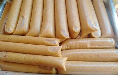 Foto da receita de Geladinho de Coco Queimado. Observa-se uma bandeja com vários saquinhos de geladinho amarronzados. Foto da receita de Geladinho de Coco Queimado. Observa-se uma bandeja com vários saquinhos de geladinho amarronzados.
