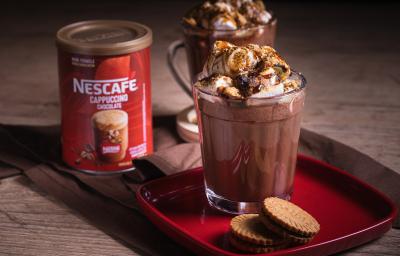 Receita de smorecaccino servida em duas canecas de vidro sobre uma mesa de madeira