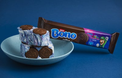 Cubos de sobremesa com creme marmorizado azul e branco e biscoitos de chocolate, com embalagem Bono ao fundo.