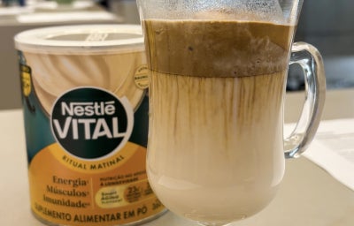 Fotografia em tons de amarelo e verde, com uma xícara e um café dentro.