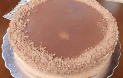 Fotografia de uma torta de chocolate com morangos sobre um apoio de metal. Fotografia de uma torta de chocolate com morangos sobre um apoio de metal.