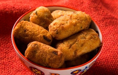 Foto aproximada da receita de Bolinho de Pirarucu, servido em um pote sobre uma toalha vermelha Foto aproximada da receita de Bolinho de Pirarucu, servido em um pote sobre uma toalha vermelha