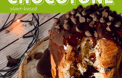 Foto em tons de marrom da receita de chocotone plant-based servida com calda de chocolate vegano sobre uma tábua de madeira redonda. Ao fundo, há uma embalagem de bebida vegetal de castanha de caju natures heart Foto em tons de marrom da receita de chocotone plant-based servida com calda de chocolate vegano sobre uma tábua de madeira redonda. Ao fundo, há uma embalagem de bebida vegetal de castanha de caju natures heart