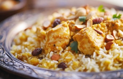 Um prato de Arroz Natal é apresentado em um prato, repleto de arroz soltinho e colorido. O arroz é misturado com pedaços suculentos de peito de frango, ervilhas verdes e uvas-passas. Um prato de Arroz Natal é apresentado em um prato, repleto de arroz soltinho e colorido. O arroz é misturado com pedaços suculentos de peito de frango, ervilhas verdes e uvas-passas.